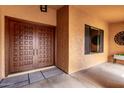 A welcoming entryway features double wood doors, textured walls, and decorative accents at 3826 E Equestrian Trl, Phoenix, AZ 85044