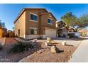 Two-story home featuring desert landscaping, a two car garage, and a driveway at 41955 W Hillman Dr, Maricopa, AZ 85138