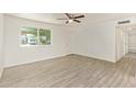 Spacious living room featuring a ceiling fan, light-colored walls, and wood-look tile flooring at 4366 E Burgess Ln, Phoenix, AZ 85042