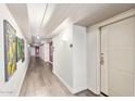 Well-lit hallway with wood-look flooring and modern wall decor at 535 W Thomas Rd # 313, Phoenix, AZ 85013