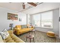 Cozy living room with a yellow sofa, patterned rug, and plenty of natural light at 535 W Thomas Rd # 313, Phoenix, AZ 85013