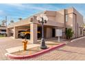 Exterior shot of the house, showcasing carports, lamp post, and a fire hydrant on a sunny day at 6159 E Indian School Rd # 110, Scottsdale, AZ 85251