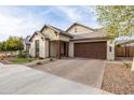 Inviting single-story home featuring a stone facade, brick driveway, and attached two-car garage at 6926 W Spur Dr, Peoria, AZ 85383