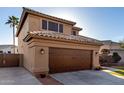 Side view of a home featuring an attached two-car garage and tiled roof at 7371 W Louise Dr, Glendale, AZ 85310