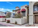 Exterior view showing manicured landscaping, red awnings, balcony, and walkway at 8840 S 51St St # 2, Phoenix, AZ 85044