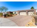 Attractive home features an expansive brick driveway, desert landscaping, and a convenient two-car garage at 10534 N 133Rd St, Scottsdale, AZ 85259