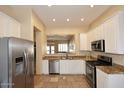 Well-equipped kitchen featuring stainless steel appliances and a breakfast bar overlooking the living area at 10572 E Tierra Buena Ln, Scottsdale, AZ 85255