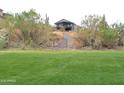 Backyard hillside with desert landscaping and a private gate at 1127 N Sherwood Way, Queen Valley, AZ 85118