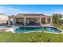 Backyard pool and spa with covered patio, outdoor living space and artificial grass at 13616 W Junipero Dr, Sun City West, AZ 85375