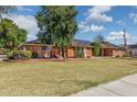 Quaint single story brick house surrounded by a lush lawn and mature landscaping at 1610 E Mclellan Rd, Mesa, AZ 85203