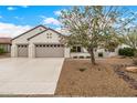 Home featuring a three-car garage and desert landscaping at 16210 W Desert Winds Dr, Surprise, AZ 85374