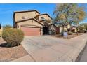 Charming two-story home showcasing a brown exterior, spacious driveway, and drought-resistant landscaping at 1713 S 117Th Dr, Avondale, AZ 85323