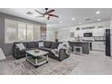 Inviting living room featuring a comfortable gray sectional, stylish coffee table, and open flow to the kitchen at 18413 W Paseo Way, Goodyear, AZ 85338