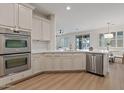 Modern kitchen with stainless steel appliances, white cabinetry, and a breakfast bar area at 2670 E Parkview Dr, Gilbert, AZ 85295