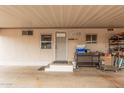 Covered parking area or carport with a white door, windows, and storage; functional and practical space at 2700 E Allred Ave # A3, Mesa, AZ 85204