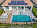Aerial view of backyard swimming pool and spa with covered patio and outdoor seating area at 29606 N Tarragona Dr, Peoria, AZ 85383