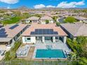 Areal view of a backyard pool and spa with covered patio, lounge seating, and mountain views at 29606 N Tarragona Dr, Peoria, AZ 85383