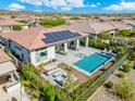 Aerial view of backyard swimming pool and spa with covered patio and outdoor seating area at 29606 N Tarragona Dr, Peoria, AZ 85383