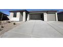 A single-story home with a large driveway and two-car garage provides ample parking at 32723 N Newby Dr, San Tan Valley, AZ 85140