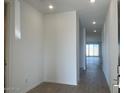 A long hallway is illuminated with recessed lighting and features wood-look tile flooring at 32723 N Newby Dr, San Tan Valley, AZ 85140