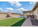 Backyard featuring artificial turf, a covered patio, and a sparkling swimming pool at 3640 W Redfield Rd, Phoenix, AZ 85053