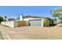 View of the house showing a private yard, block fence, mature landscaping, and a garage at 3807 E Altadena Ave, Phoenix, AZ 85028
