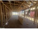 Unfinished interior shows exposed beams and studs as a home is under construction at 4276 E Brook Lynn Pl, San Tan Valley, AZ 85140