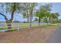 Landscaped front yard features a white fence, mature trees, and green grass at 4311 W Siesta Way, Laveen, AZ 85339