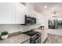 Close up of updated kitchen with stainless appliances, granite counters, and tile flooring at 5142 E Holly St, Phoenix, AZ 85008