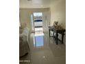 Inviting entryway with gleaming tile floors, decorative table with roses, and an open door to the outside at 6107 N 126Th Ave, Litchfield Park, AZ 85340
