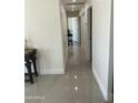Long hallway featuring tile floors and white doors, leading to various rooms of the house at 6107 N 126Th Ave, Litchfield Park, AZ 85340