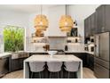 Modern kitchen with center island, pendant lighting, open shelving, and stainless steel appliances at 6438 E Montreal Pl, Scottsdale, AZ 85254