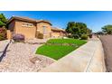 Well-maintained home featuring desert landscaping and healthy green lawn at 7150 W Avenida Del Rey --, Peoria, AZ 85383