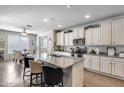 Bright kitchen with stainless steel appliances, granite counters, white cabinets, and a breakfast bar at 7363 E Plata Ave, Mesa, AZ 85212