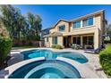 A backyard pool and spa are surrounded by a patio and lush landscaping, perfect for outdoor entertaining at 7363 E Plata Ave, Mesa, AZ 85212