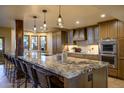 Gourmet kitchen features a huge center island, barstool seating, and custom pendant lighting at 9716 E Mariposa Grande Dr, Scottsdale, AZ 85255