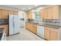 Spacious kitchen featuring ample cabinet space, tile backsplash, modern appliances, and convenient laundry area at 10816 W Hatcher Rd, Sun City, AZ 85351