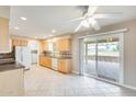 Bright kitchen with tile flooring, wooden cabinets, and sliding door access to the covered patio at 10816 W Hatcher Rd, Sun City, AZ 85351