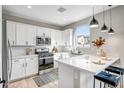 Bright kitchen with stainless steel appliances and a large island with counter seating and pendant lighting at 10823 W Polk St, Avondale, AZ 85323