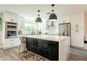 Bright kitchen with stainless steel appliances, a large island with seating, and modern white cabinets at 10903 E Sahuaro Dr, Scottsdale, AZ 85259