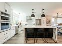 Beautiful kitchen with stainless steel appliances, a large island with seating, and modern white cabinets at 10903 E Sahuaro Dr, Scottsdale, AZ 85259