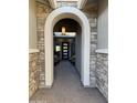 Inviting front porch with stone archway and outdoor seating at 11612 W Candelilla Way, Peoria, AZ 85383