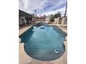 Outdoor in-ground swimming pool with a colorful sun umbrella and adjacent jacuzzi for backyard enjoyment at 1172 E Delano Dr, Casa Grande, AZ 85122