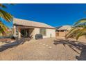 View of the backyard patio and desert landscaping with block wall and a clear blue sky at 14787 W Aster Dr, Surprise, AZ 85379