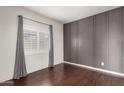 Modern bedroom with hard wood floors and a designer accent wall for visual appeal at 16549 W Rowel Rd, Surprise, AZ 85387
