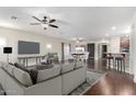 Open-concept living room featuring a comfortable sofa, ceiling fans, and seamless flow to the dining and kitchen areas at 16549 W Rowel Rd, Surprise, AZ 85387