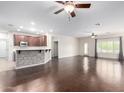 Expansive living room with hardwood floors, ceiling fans, and open to kitchen at 16549 W Rowel Rd, Surprise, AZ 85387