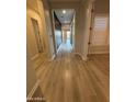 A bright and airy hallway features new light-colored floors that run the length of the house at 17019 W Cameron Dr, Surprise, AZ 85388