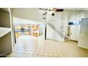 Open-concept living space with tiled floors, staircase, and seamless flow into the kitchen at 17059 W Northampton Rd, Surprise, AZ 85374