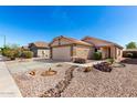 Beautiful desert landscaped front yard and attached two car garage make for an inviting home at 22569 W Lasso Ln, Buckeye, AZ 85326